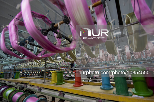 A worker is working at a workshop of a textile company in Haian, Jiangsu Province, East China, on December 14, 2023. 