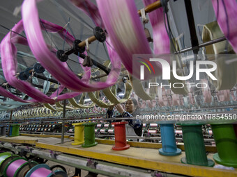 A worker is working at a workshop of a textile company in Haian, Jiangsu Province, East China, on December 14, 2023. (