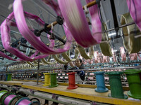 A worker is working at a workshop of a textile company in Haian, Jiangsu Province, East China, on December 14, 2023. (