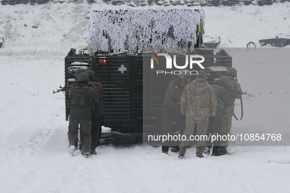 Servicemen are taking cover behind an APC while senior sergeants from the units of the Eastern Operational and Territorial Command of the Na...