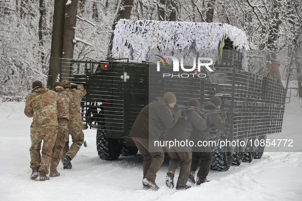 Servicemen are taking cover behind an APC while senior sergeants from the units of the Eastern Operational and Territorial Command of the Na...