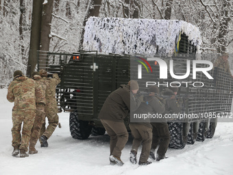 Servicemen are taking cover behind an APC while senior sergeants from the units of the Eastern Operational and Territorial Command of the Na...