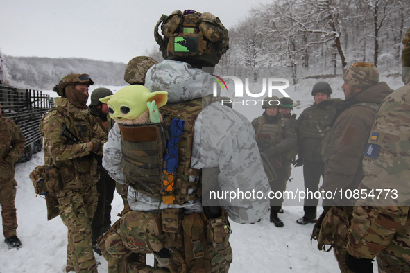 In Kharkiv Region, Ukraine, on December 14, 2023, a serviceman is carrying a Baby Yoda toy in the pocket at the back of his bulletproof vest...