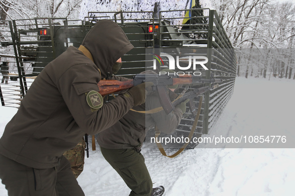 Servicemen are taking cover behind an APC while senior sergeants from the units of the Eastern Operational and Territorial Command of the Na...