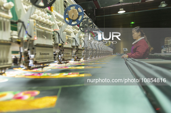 A worker is making embroidery orders at a workshop of a textile enterprise in Congjiang County, Guizhou Province, China, on December 15, 202...