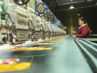 A worker is making embroidery orders at a workshop of a textile enterprise in Congjiang County, Guizhou Province, China, on December 15, 202...