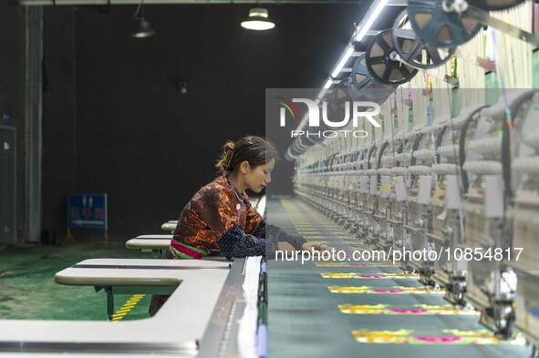 A worker is making embroidery orders at a workshop of a textile enterprise in Congjiang County, Guizhou Province, China, on December 15, 202...