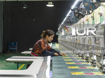 A worker is making embroidery orders at a workshop of a textile enterprise in Congjiang County, Guizhou Province, China, on December 15, 202...