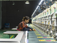 A worker is making embroidery orders at a workshop of a textile enterprise in Congjiang County, Guizhou Province, China, on December 15, 202...