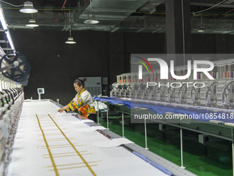 A worker is making embroidery orders at a workshop of a textile enterprise in Congjiang County, Guizhou Province, China, on December 15, 202...