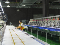 A worker is making embroidery orders at a workshop of a textile enterprise in Congjiang County, Guizhou Province, China, on December 15, 202...