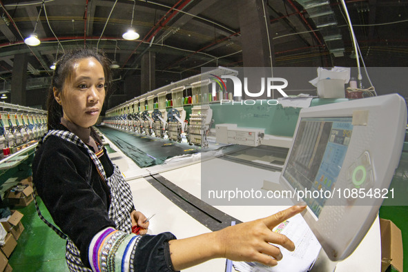 A worker is making embroidery orders at a workshop of a textile enterprise in Congjiang County, Guizhou Province, China, on December 15, 202...