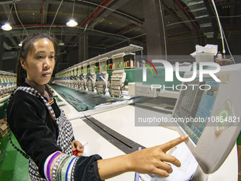 A worker is making embroidery orders at a workshop of a textile enterprise in Congjiang County, Guizhou Province, China, on December 15, 202...