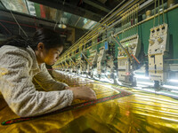 A worker is making embroidery orders at a workshop of a textile enterprise in Congjiang County, Guizhou Province, China, on December 15, 202...