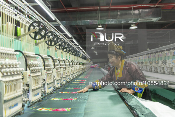 A worker is making embroidery orders at a workshop of a textile enterprise in Congjiang County, Guizhou Province, China, on December 15, 202...