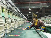 A worker is making embroidery orders at a workshop of a textile enterprise in Congjiang County, Guizhou Province, China, on December 15, 202...