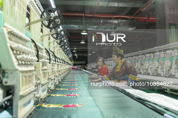 A worker is making embroidery orders at a workshop of a textile enterprise in Congjiang County, Guizhou Province, China, on December 15, 202...