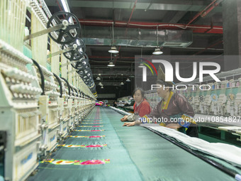 A worker is making embroidery orders at a workshop of a textile enterprise in Congjiang County, Guizhou Province, China, on December 15, 202...