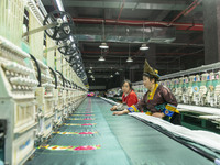 A worker is making embroidery orders at a workshop of a textile enterprise in Congjiang County, Guizhou Province, China, on December 15, 202...