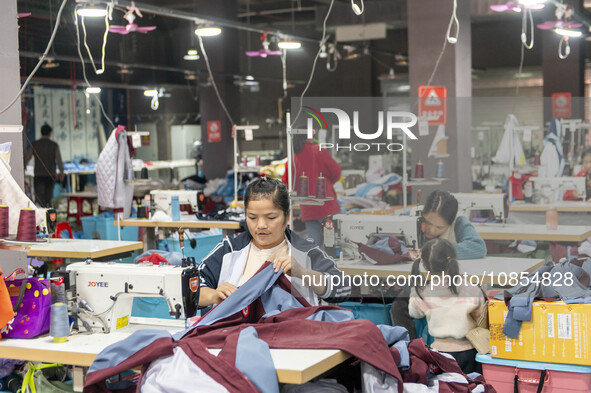 Workers are making an order at a workshop of a clothing company in Congjiang County, Southwest China's Guizhou Province, on December 15, 202...