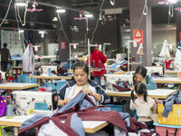 Workers are making an order at a workshop of a clothing company in Congjiang County, Southwest China's Guizhou Province, on December 15, 202...