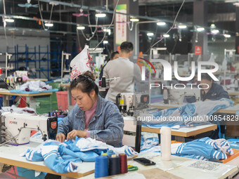 Workers are making an order at a workshop of a clothing company in Congjiang County, Southwest China's Guizhou Province, on December 15, 202...