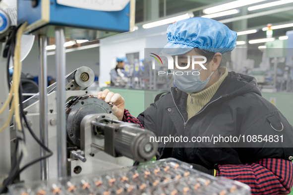 A worker is producing motor products at a motor production workshop in Nantong, Jiangsu Province, China, on December 15, 2023. 