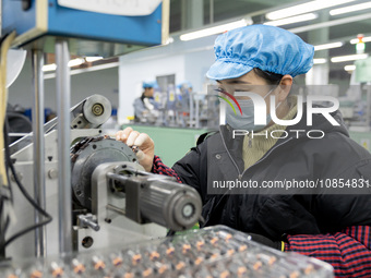 A worker is producing motor products at a motor production workshop in Nantong, Jiangsu Province, China, on December 15, 2023. (