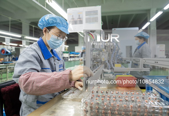 A worker is producing motor products at a motor production workshop in Nantong, Jiangsu Province, China, on December 15, 2023. 