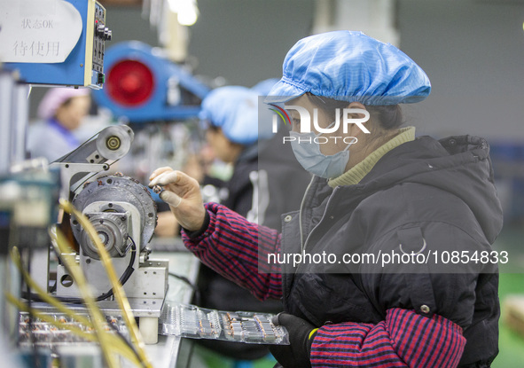 A worker is producing motor products at a motor production workshop in Nantong, Jiangsu Province, China, on December 15, 2023. 