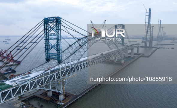 Builders are working in the snow at the construction site of the Changtai Yangtze River Bridge in Taixing, Jiangsu Province, East China, on...