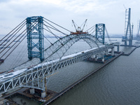 Builders are working in the snow at the construction site of the Changtai Yangtze River Bridge in Taixing, Jiangsu Province, East China, on...