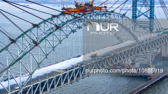 Builders are working in the snow at the construction site of the Changtai Yangtze River Bridge in Taixing, Jiangsu Province, East China, on...