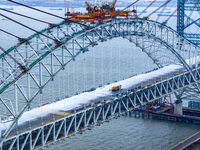 Builders are working in the snow at the construction site of the Changtai Yangtze River Bridge in Taixing, Jiangsu Province, East China, on...