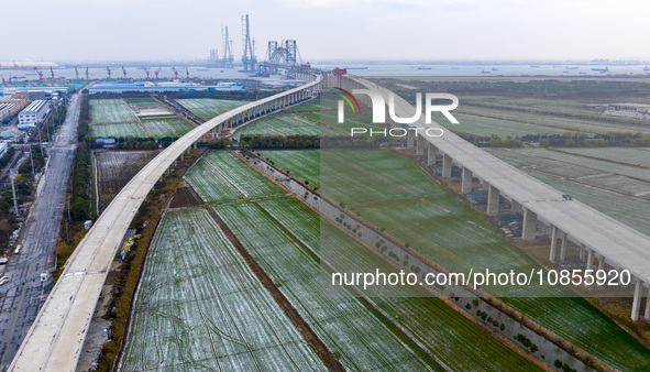 Builders are working in the snow at the construction site of the Changtai Yangtze River Bridge in Taixing, Jiangsu Province, East China, on...