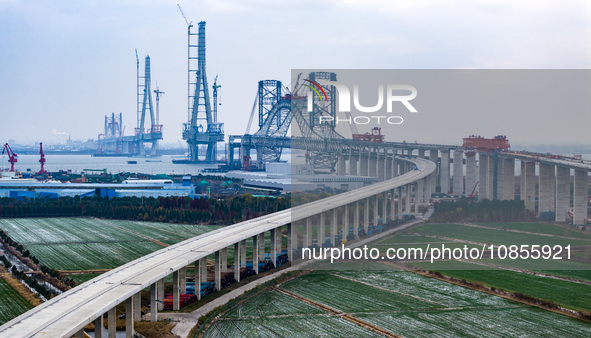 Builders are working in the snow at the construction site of the Changtai Yangtze River Bridge in Taixing, Jiangsu Province, East China, on...