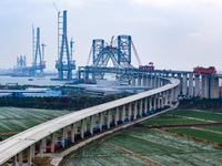 Builders are working in the snow at the construction site of the Changtai Yangtze River Bridge in Taixing, Jiangsu Province, East China, on...