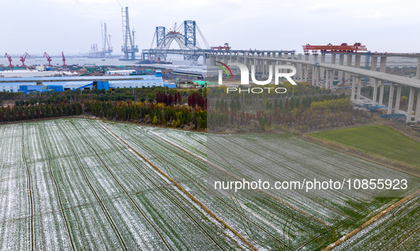 Builders are working in the snow at the construction site of the Changtai Yangtze River Bridge in Taixing, Jiangsu Province, East China, on...