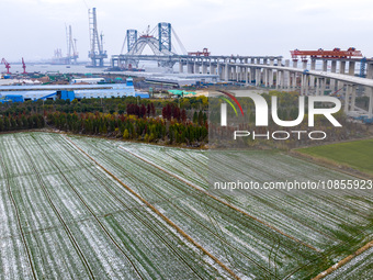 Builders are working in the snow at the construction site of the Changtai Yangtze River Bridge in Taixing, Jiangsu Province, East China, on...