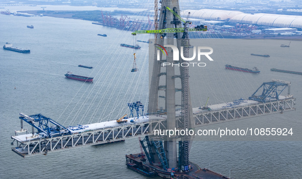 Builders are working in the snow at the construction site of the Changtai Yangtze River Bridge in Taixing, Jiangsu Province, East China, on...