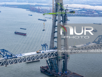 Builders are working in the snow at the construction site of the Changtai Yangtze River Bridge in Taixing, Jiangsu Province, East China, on...