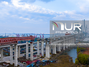 Builders are working in the snow at the construction site of the Changtai Yangtze River Bridge in Taixing, Jiangsu Province, East China, on...