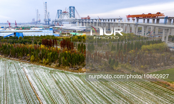 Builders are working in the snow at the construction site of the Changtai Yangtze River Bridge in Taixing, Jiangsu Province, East China, on...