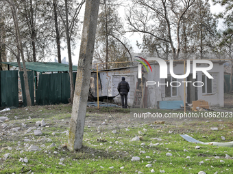 Men are standing by a building damaged by Russian shelling in the Odesa Region, southern Ukraine, on December 17, 2023. (