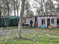 Men are standing by a building damaged by Russian shelling in the Odesa Region, southern Ukraine, on December 17, 2023. (