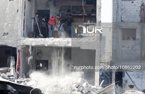 Palestinians are gathering amid the rubble of destroyed buildings following an Israeli bombardment in Deir El-Balah, in the central Gaza Str...