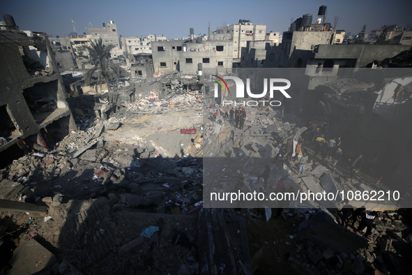 Palestinians are gathering amid the rubble of destroyed buildings following an Israeli bombardment in Deir El-Balah, in the central Gaza Str...