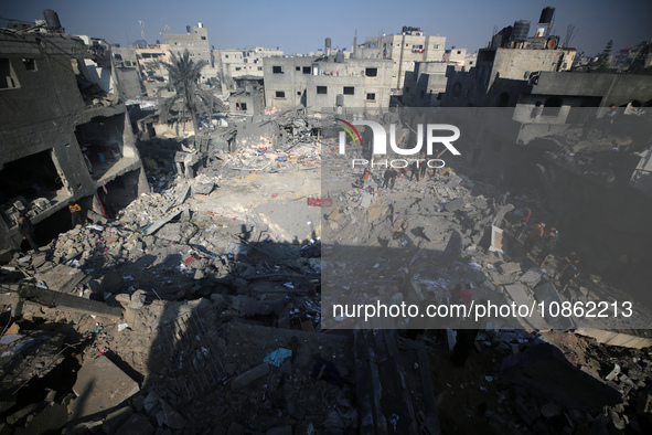 Palestinians are gathering amid the rubble of destroyed buildings following an Israeli bombardment in Deir El-Balah, in the central Gaza Str...