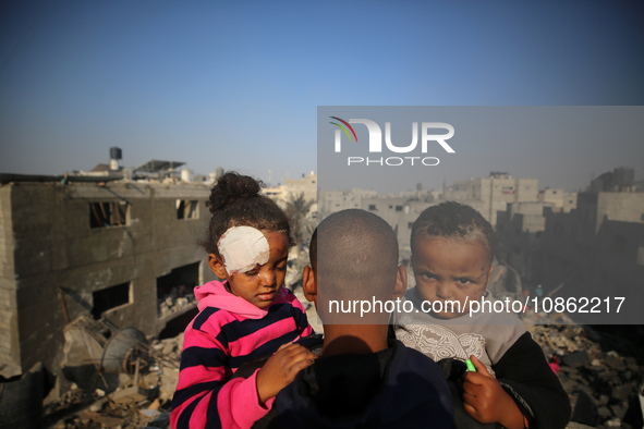 Palestinians are gathering amid the rubble of destroyed buildings following an Israeli bombardment in Deir El-Balah, in the central Gaza Str...