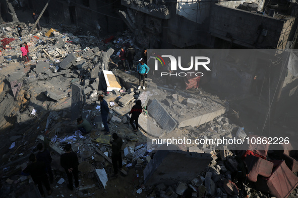 Palestinians are gathering amid the rubble of destroyed buildings following an Israeli bombardment in Deir El-Balah, in the central Gaza Str...